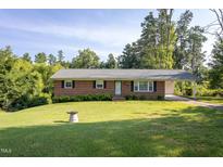 Charming brick home with a lush, green front yard and mature trees at 3603 Grimes Ave, Durham, NC 27703