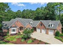 Stunning brick home featuring a three car garage and manicured landscaping at 5204 Winter Holly Ct, Raleigh, NC 27606