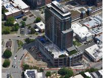 Aerial view of high-rise building showing the building within the surrounding neighborhood, streets, and parking areas at 400 W Main St # 2007, Durham, NC 27701