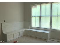 Bright, unfinished room showcasing a custom window seat with built-in storage and natural light at 72 Hazelwood, Pittsboro, NC 27312