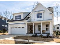 Charming two-story white farmhouse with a covered front porch and attached two-car garage at 167 Edgefield St, Pittsboro, NC 27312