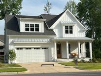 Charming two-story home with white siding, a covered front porch, and a two car garage at 167 Edgefield St, Pittsboro, NC 27312