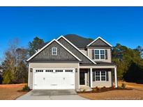 Two-story house with gray and beige siding, white garage door, and landscaping at 36 Fort Mcclary Ct, Cameron, NC 28326