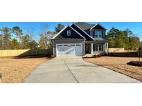 Two-story house with gray siding, white garage door, and a long driveway at 36 Fort Mcclary Ct, Cameron, NC 28326