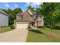 Charming two-story home with stone accents, a well-manicured lawn, and attached two-car garage at 14 Valley Brook Ln, Spring Lake, NC 28390
