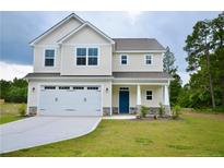 Charming two-story home with a well-manicured lawn, two-car garage and inviting blue front door at 2937 Lemuel Black Rd, Bunnlevel, NC 28323