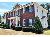 Two-story brick home with a welcoming front porch and landscaping at 11 Antique Ct, Cameron, NC 28326