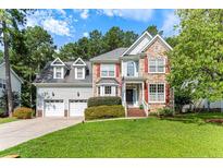 Charming two-story home featuring stone accents, dormer windows, two-car garage, and a lush green lawn at 367 Falling Water Rd, Spring Lake, NC 28390