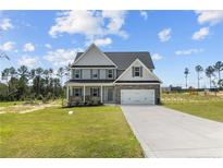 Two story house with gray siding, stone accents, and a two car garage at 830 Cypress Rd, Cameron, NC 28326