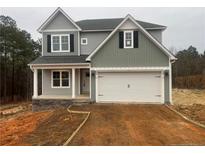 Two-story house with gray siding, white garage door, and stone accents at 114 Kingwood Dr, Lillington, NC 27546