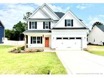 Two-story home with white siding, orange door, and attached garage at 125 Shadybrook Dr, Benson, NC 27504