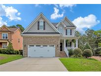 Brick two-story house with a three-car garage and landscaped lawn at 738 N Micahs Way, Spring Lake, NC 28390