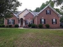 Charming brick home with manicured lawn and classic architectural details at 9404 Perimeter Ct, Zebulon, NC 27597