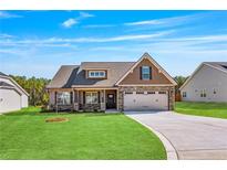 Charming single Gathering home with stone accents, a two-car garage and a well maintained lawn at 258 Thistle Ct, Sanford, NC 27332