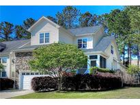 Charming two-story home featuring stone accents, well-maintained landscaping, and attached garage at 197 Lamplighter Way, Spring Lake, NC 28390