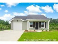 Newly constructed home with a gray exterior, attached garage, and well-manicured lawn at 903 Windrace Trl, Sanford, NC 27332