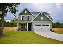 Charming two-story home featuring a two-car garage, lush lawn, and well-maintained landscaping at 2885 Lemuel Black Rd, Bunnlevel, NC 28323