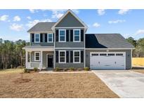 Charming two-story home featuring a two-car garage, classic black shutters and gray siding, and a well-manicured lawn at 732 Burley Oak Dr, Cameron, NC 28326