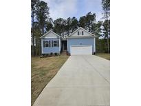 Charming, single-story home with blue siding, attached garage, and a well-manicured front lawn at 8026 Royal Dr, Sanford, NC 27332