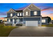 Two-story home with blue siding, large windows, and a three-car garage at 5554 Lake Vista Ct, Rocky Mount, NC 27803