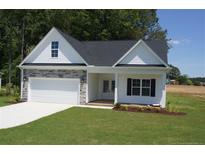 Charming home featuring stone accents, a two-car garage, manicured lawn, and classic black shutters at 123 Nectar Ln, Bunnlevel, NC 28323