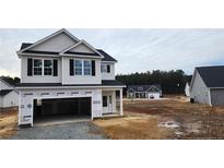 Two-story house with attached garage and vinyl siding at 154 Nectar Ln, Bunnlevel, NC 28323