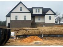 Two-story home with white siding, brick base, black accents, and unfinished landscaping at 196 Hook Dr, Fuquay Varina, NC 27526