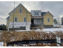 Two-story house with light yellow siding, a large front yard, and a partially snow-covered landscape at 196 Hook Dr, Fuquay Varina, NC 27526