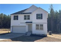 Charming two-story home featuring a classic white facade, black shutters, and an attached garage at 6200 Sheriff Watson Rd, Sanford, NC 27332