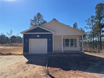 Newly constructed home with white and blue siding, a garage, and a covered porch at 5011 (Lot 5) Ray Rd, Spring Lake, NC 28390