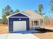 Charming single-story home featuring a blue and white exterior, attached garage, and manicured lawn at 5011 (Lot 5) Ray Rd, Spring Lake, NC 28390