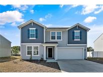 Two-story house with gray and blue siding, a two-car garage, and a landscaped yard at 299 Hallow Oak St, Spring Lake, NC 28390