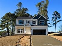 Charming two-story home with a light-colored facade, two-car garage, and freshly poured concrete driveway at 78 Bennett Rd, Coats, NC 27521