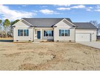Newly constructed one-story home with beige vinyl siding, gray roof, and a two-car garage at 52 Roll Tide Ct, Angier, NC 27501