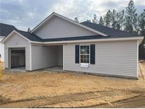 New construction home features an attached two-car garage, gray siding, and a modern black roof at 302 Rocking Horse Ln, Sanford, NC 27332