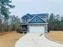 Two-story house with gray siding, stone accents, and a two-car garage at 886 Juno Dr, Broadway, NC 27505