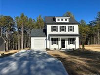 Two-story farmhouse style home with white siding, black shutters, and a gray roof at 806 Roberts Rd, Sanford, NC 27332