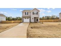 Charming two-story home with a gray exterior, a well-manicured lawn, and an attached one car garage at 912 Allstar Ave, Cameron, NC 28326