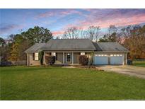 Charming single-story home featuring well-manicured lawn and a convenient two-car garage at 58 Bayleaf Ln, Sanford, NC 27332