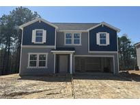 Two-story home featuring gray siding, blue accents, a two-car garage, and white-framed windows at 22 Bennington Way, Lillington, NC 27546