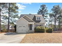 Charming home featuring manicured landscaping, a single-car garage, and a welcoming front entrance at 696 Valley Oak Dr, Bunnlevel, NC 28323