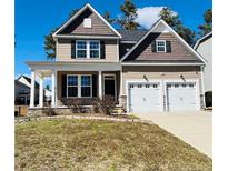 Traditional two-story home with a two-car garage, covered porch, and manicured front lawn at 137 Falls Creek Dr, Spring Lake, NC 28390