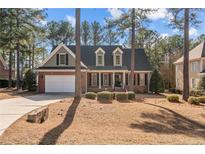 Brick house with gray shutters, a white garage door, and landscaping at 60 Rolling Pines Dr, Spring Lake, NC 28390