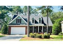 Charming brick two-story home with well-manicured landscaping and an attached two-car garage at 60 Rolling Pines Dr, Spring Lake, NC 28390