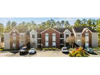 Brick building exterior with ample parking and a tree-lined setting at 62 Gallery Dr # 204, Spring Lake, NC 28390