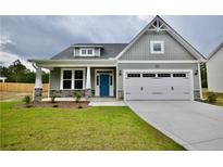 Charming one-story home featuring a manicured lawn, stone accents, and a welcoming blue front door at 2919 Lemuel Black Rd, Bunnlevel, NC 28323