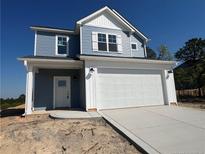 Two-story home featuring light blue siding, white trim, and an attached two-car garage at 17 Tackett Ct, Lillington, NC 27546