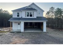 Two story home featuring an open two-car garage, white siding, and a dark roof at 48 Tackett Ct, Lillington, NC 27546