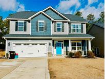 Two-story house featuring gray and blue siding, a white door, and a two-car garage at 183 Kensington Dr, Spring Lake, NC 28390