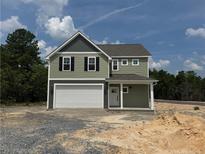 Charming two-story home featuring a two-car garage, well-manicured lawn, and traditional architectural details at 24 Tackett Ct, Lillington, NC 27546